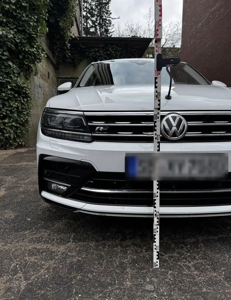 Frontansicht eines Fahrzeugs mit Messlatte bei der Besichtigung durch den Kfz-Gutachter
